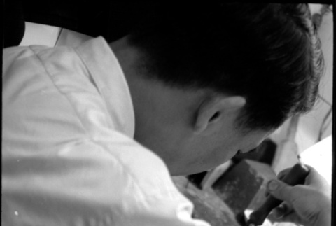 Man working with small saw, possibly a jeweler (ddr-densho-426-2409)