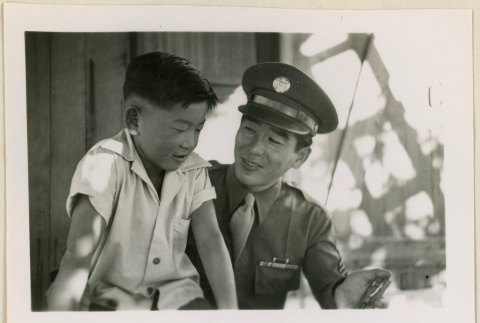 Sgt. Komoto shows his Purple Heart medal to a boy (ddr-densho-37-996)