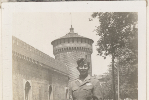 Man standing outside brick building with tower (ddr-densho-466-340)