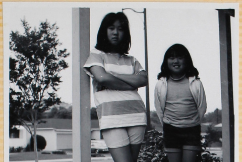 Two girls standing on porch (ddr-densho-522-109)