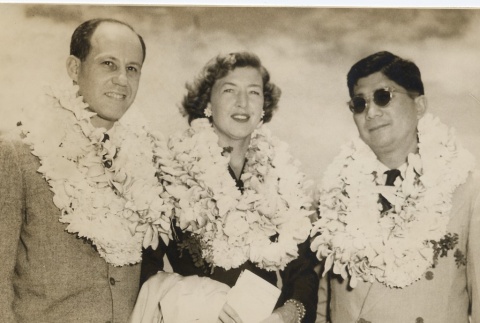 Two men and a woman wearing leis (ddr-njpa-1-1128)