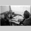 Loni Ding, Barry Saiki and Harry Fukuhara looking through clippings (ddr-densho-1007-1166)