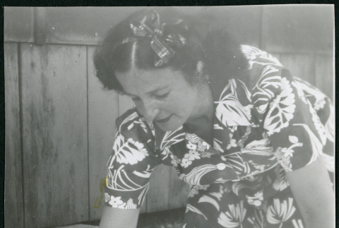 Photograph of Irene Gavigan leaning over an infant at Manzanar (ddr-csujad-47-227)