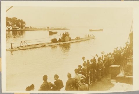 Men at a dock waving to sailors on a passing U-boat (ddr-njpa-13-998)