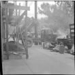 Pacific Coast Aggregates dump truck unloading at construction site (ddr-densho-426-1768)