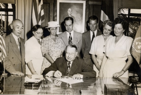 John H. Wilson signing a document while others look on (ddr-njpa-2-897)