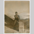 William Iino sitting on stone ledge (ddr-densho-368-271)