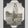Woman standing with barracks in background (ddr-densho-466-198)