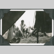 Man sitting on gear outside tent (ddr-ajah-2-261)