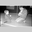 Man with child on gym floor (ddr-densho-1007-1257)