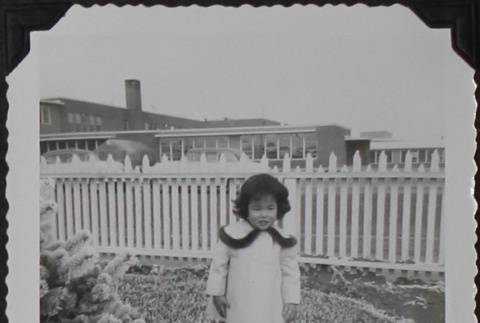 A girl standing in front of a fence (ddr-densho-300-511)