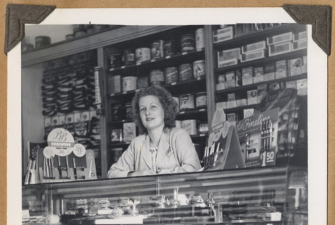 Woman standing behind a glass case (ddr-densho-542-107)