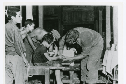 Surgeon Lt. Milton B. Sorem treating Okinawan girl (ddr-densho-1007-81)