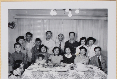 Group of adults and children posing by dinner table (ddr-densho-522-552)