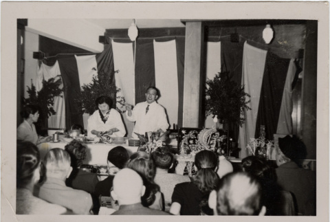 Man and woman giving cooking demonstration (ddr-densho-426-869)