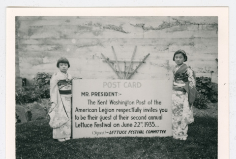 Two children with over-sized postcard from Lettuce Festival Committee (ddr-densho-1007-14)