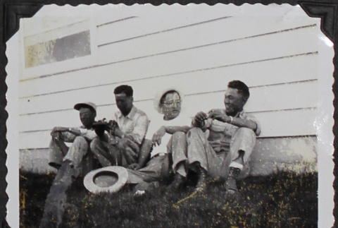Four men sitting against a building (ddr-densho-300-443)