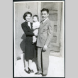 Photograph of Jean and Togo Tanaka with daughter Iye posing in front of a door in Cow Creek Camp in Death Valley (ddr-csujad-47-130)
