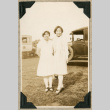 Two women standing near car dressed in white (ddr-densho-383-120)