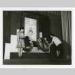 Woman adjusting wreaths at memorial service (ddr-densho-1007-347)