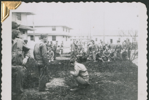 Group of men standing and sitting in patch of dug-up ground (ddr-densho-434-87)
