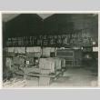 Workfloor of a factory showing the following writing on the wall: 