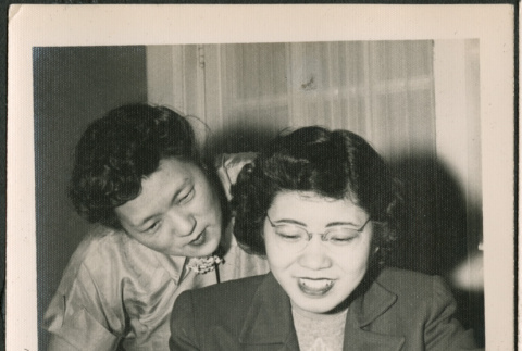 Two women looking at photos (ddr-densho-293-160)