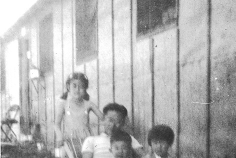 Eiko Hibiya poses with a seated man and two children (ddr-densho-381-184)