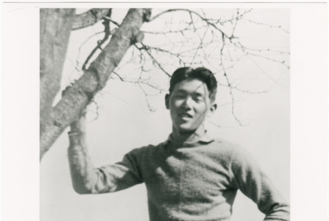 Young man standing by tree (ddr-densho-122-616)