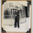 Man standing in front of a sign (ddr-densho-542-150)