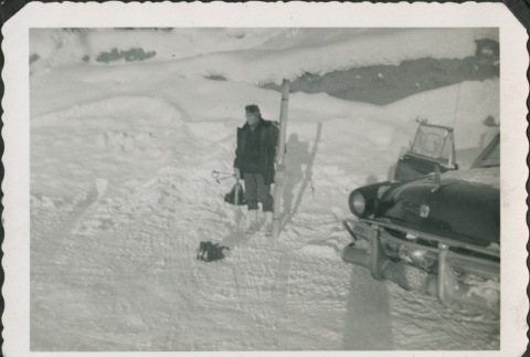 Man holding skis near a car (ddr-densho-321-305)