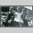 Photograph of children sitting on a bench in front of the Manzanar hospital (ddr-csujad-47-216)