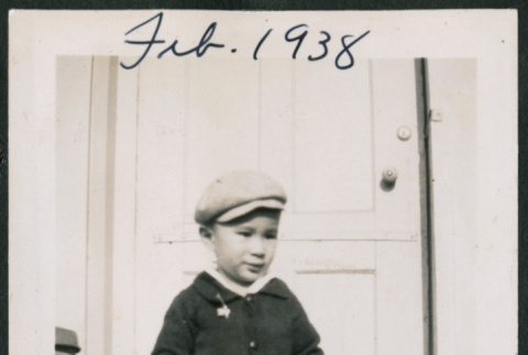 Photo of a child in front of a door (ddr-densho-483-712)