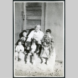 Photograph of Grandpa Tayama surrounded by five children in front of a door in Cow Creek Camp in Death Valley (ddr-csujad-47-132)
