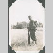 Man standing with rifle and pack (ddr-ajah-2-204)