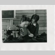 Still scene of Misa Wakatsuki (Nobu McCarthy) sewing for Jeanne Wakatsuki (Dori Takeshita) (ddr-densho-317-6)