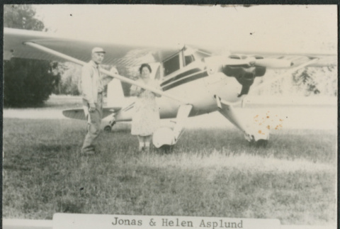 Season's greeting card with couple by small plane (ddr-densho-523-616)
