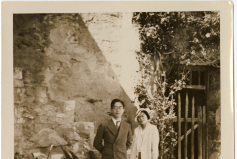 Tomoye (Nozawa) Takahashi and unknown man by stone wall (ddr-densho-426-1784)