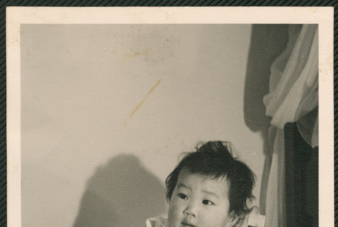 Toddler laying on bed (ddr-densho-522-739)