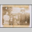 Man and woman with five children by stone pillar (ddr-densho-483-1009)