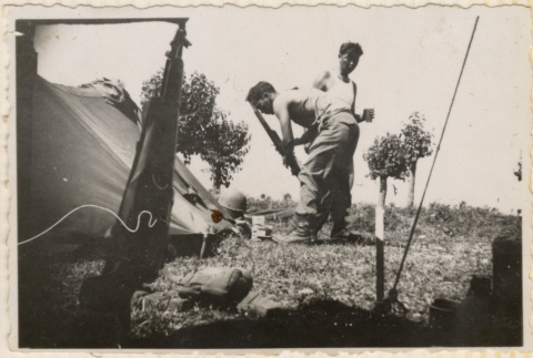 Two men outside tent, taken from inside another tent (ddr-densho-466-385)
