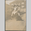 Two children riding tricycle with dog (ddr-densho-523-52)