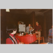 Tomoye and Henri Takahashi standing by table with gifts (ddr-densho-426-1292)