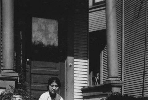 Mary Kondo sitting on steps of house (ddr-ajah-6-115)