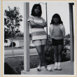 Two girls standing on porch (ddr-densho-522-109)