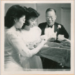 Tomoye (Nozawa) Takahashi and Martha Nozawa with unidentified man looking at a box of flowers (ddr-densho-410-522)