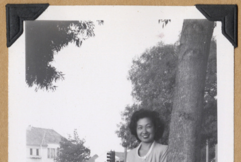 Woman posing next to a tree (ddr-densho-542-332)
