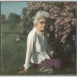 Agnes Sakura sitting on lawn by flowers (ddr-densho-523-660)
