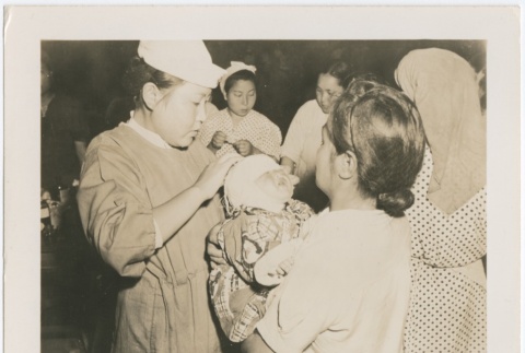Japanese nurse bandages injured infant (ddr-densho-299-43)