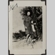 Woman standing by tree trunk (ddr-densho-587-49)